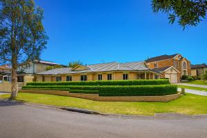 a large house with hedges in front of it at Emmaus Hill in Blue Haven