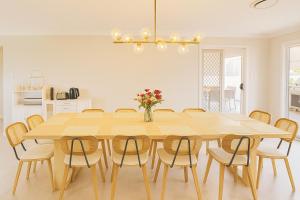 a dining room table with chairs and a vase of flowers at Emmaus Hill in Blue Haven
