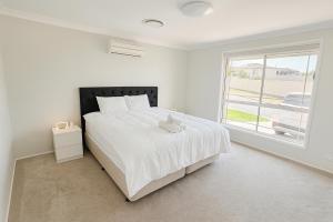 a white bedroom with a large bed and a window at Emmaus Hill in Blue Haven +18 photos