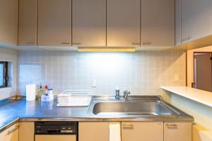 a kitchen with a stainless steel sink and cabinets at kagoshima take in Kagoshima +73 photos
