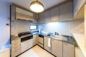 a small kitchen with a sink and a stove at kagoshima take in Kagoshima