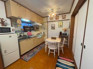 a kitchen with a table and chairs and a refrigerator at Green Hights Residence-106 in Naha