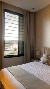 a bedroom with a large bed and a window at Velora Suites in Abha
