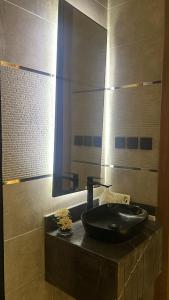 a bathroom with a black sink and a mirror at Velora Suites in Abha +19 photos