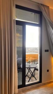 a room with a sliding glass door with a table at Velora Suites in Abha