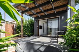a home with a glass door and a patio at Modern Studio with Outdoor Bath and Cabin Sauna in Albion Park