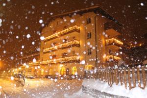 a building on a street in the snow at Hotel Rosalpina in Folgaria