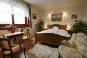 a bedroom with a bed and a chair and a table at Apartmány ReMi Vysoké Tatry in Starý Smokovec