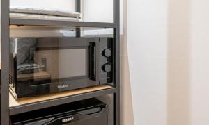 a microwave oven sitting on top of a shelf at Brown Dot Hotel NamGumi in Yangji-mal