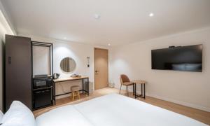 a hotel room with a bed and a desk and a television at Brown Dot Hotel NamGumi in Yangji-mal