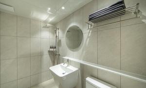 a white bathroom with a sink and a mirror at Brown Dot Hotel NamGumi in Yangji-mal +49 photos