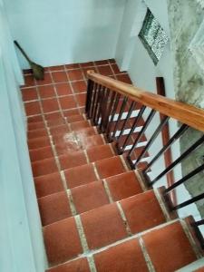 a staircase with red bricks and a wooden rail at Nord House Laoag 7 in Laoag +1 photo