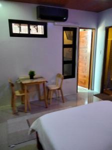 a bedroom with a table and a table and chairs at Nord House Laoag 7 in Laoag