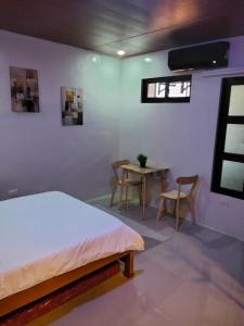 a bedroom with a bed and a table and chairs at Nord House Laoag 7 in Laoag