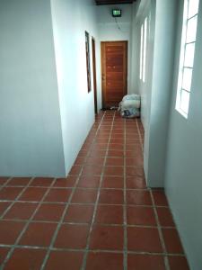 a hallway with a red tile floor and a door at Nord House Laoag 7 in Laoag