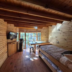 a room with a bed and a desk in a log cabin at Lodge De Ñuble in Las Trancas