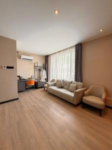a living room with a couch and two chairs at I Fly Hotel BSI in Tawau