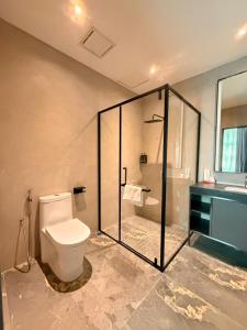 a bathroom with a toilet and a shower and a sink at I Fly Hotel BSI in Tawau