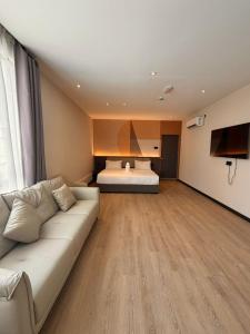 a living room with a couch and a bed at I Fly Hotel BSI in Tawau