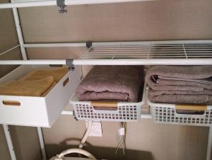 a walk in closet with white shelves and towels at 時の宿 in Kawagoe