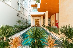 a swimming pool in the middle of a building with plants at My Khe Hotel in Danang