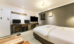 a bedroom with a bed and a desk with a computer at The Stay Series in Daegu