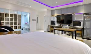 a bedroom with a large bed and a living room at The Stay Series in Daegu