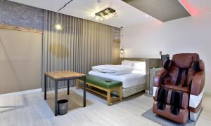 a bedroom with a bed and a table and a chair at The Stay Series in Daegu