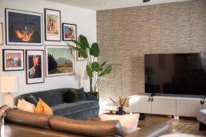 a living room with a blue couch and a large television at Astra B, Designer 3BR, Arcade, Heated Pool in Port Isabel