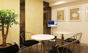 two tables and chairs in a room with a tv at Paju Geumchon Grache in Paju