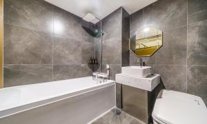 a bathroom with a tub and a toilet and a sink at Paju Geumchon Grache in Paju +17 photos