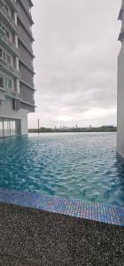 a large swimming pool next to a building at KP1011 Guest House in Puchong