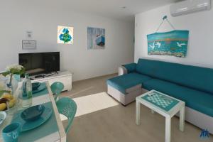 a living room with a blue couch and a table at Arthouse Sea View - Acquamarina e Zaffiro in Puerto del Carmen +17 photos