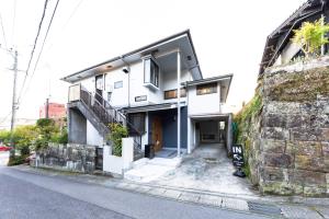 a white building with a staircase next to a wall at kagoshima take in Kagoshima