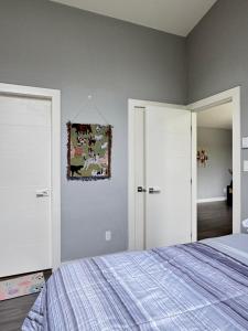 a bedroom with a bed and two white doors at Lakeside Home on Second Floor in Langford