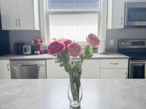 a vase filled with pink roses sitting on a table at Lakeside Home on Second Floor in Langford +15 photos