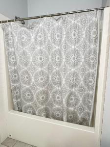 a shower curtain in a bathroom with a shower curtain at Lakeside Home on Second Floor in Langford