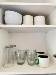 a shelf with bowls and plates and other dishes at Lakeside Home on Second Floor in Langford