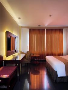 a hotel room with a bed and a desk at Citra Boutique Hotel Cikarang in Cikarang +19 photos
