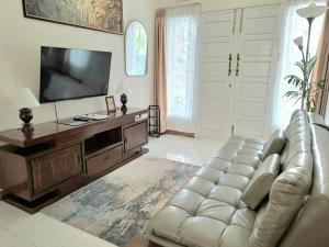 un soggiorno con un divano e una TV a schermo piatto di Dacha a Bukittinggi