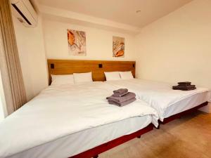 two beds sitting next to each other in a bedroom at Simplex-Iriya in Tokyo