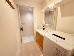 a white bathroom with a sink and a shower at Simplex-Iriya in Tokyo +66 photos
