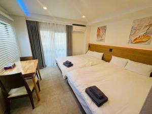 a hotel room with two beds and a table at Simplex-Iriya in Tokyo
