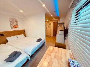 a small bedroom with a bed and a table at Simplex-Iriya in Tokyo