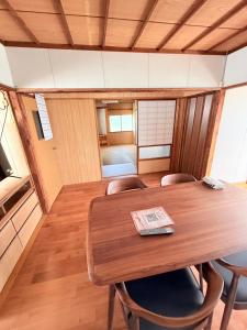 a dining room with a wooden table and chairs at ゲストハウスめぐみ in Iizuka +5 photos