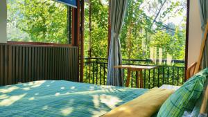 a bedroom with a bed and a balcony with a table at Angels Homestay & Coffee - Măng Đen in Kon Von Kla