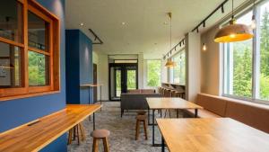 a restaurant with tables and chairs and windows at YuiLocalZao in Zaō Onsen