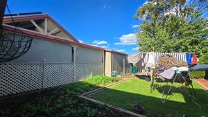 a backyard of a house with a fence at Peaceful Haven Guest House, in Adelaide