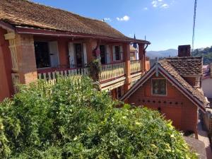an old house with a balcony in a village at Chez Julienne in Fianarantsoa