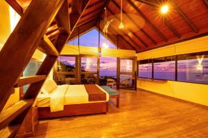 a bedroom with a bed in a room with large windows at Park Paradise in Galle